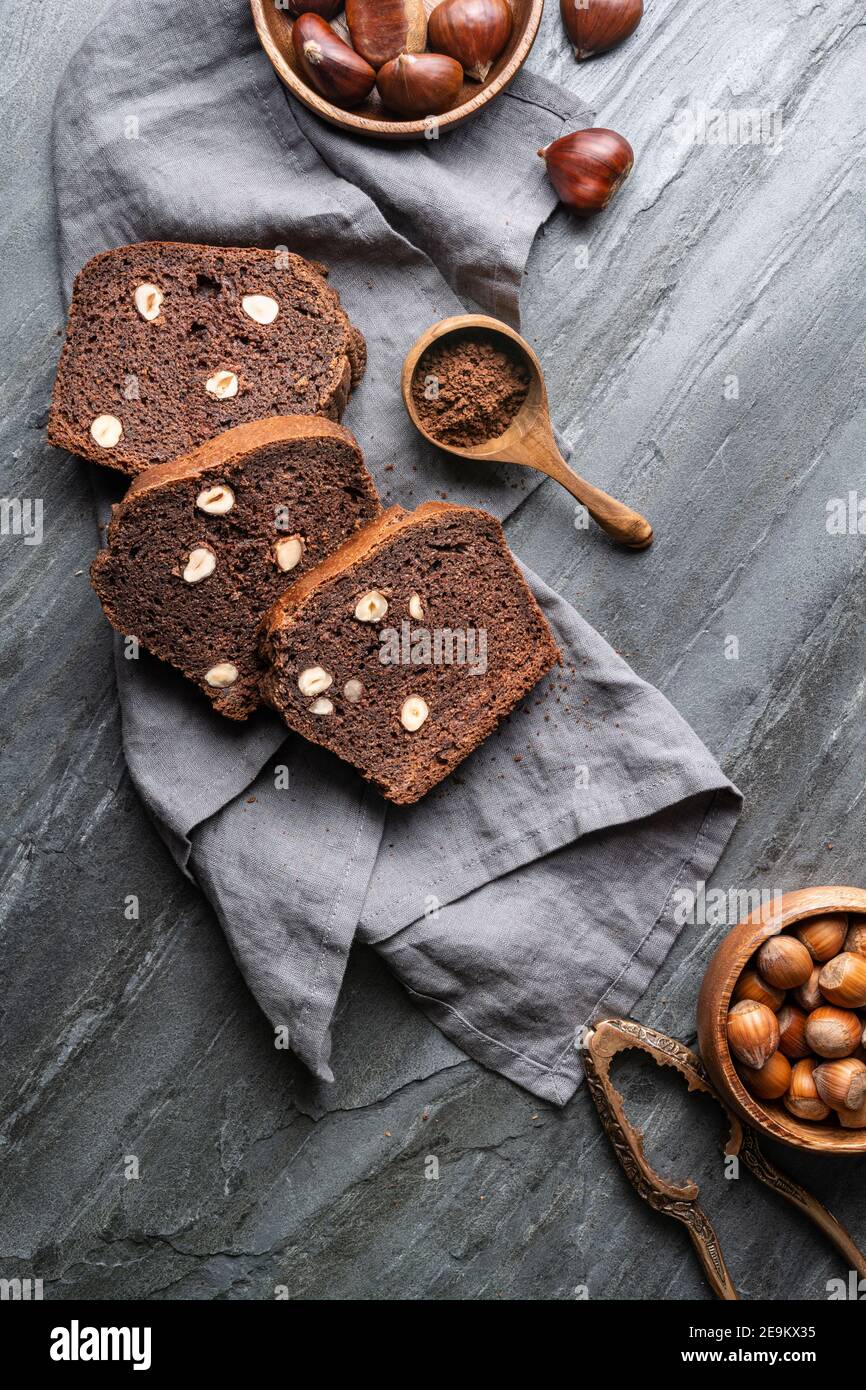 Slices of sweet chestnut bread with cocoa and hazelnuts on rustic stone background Stock Photo