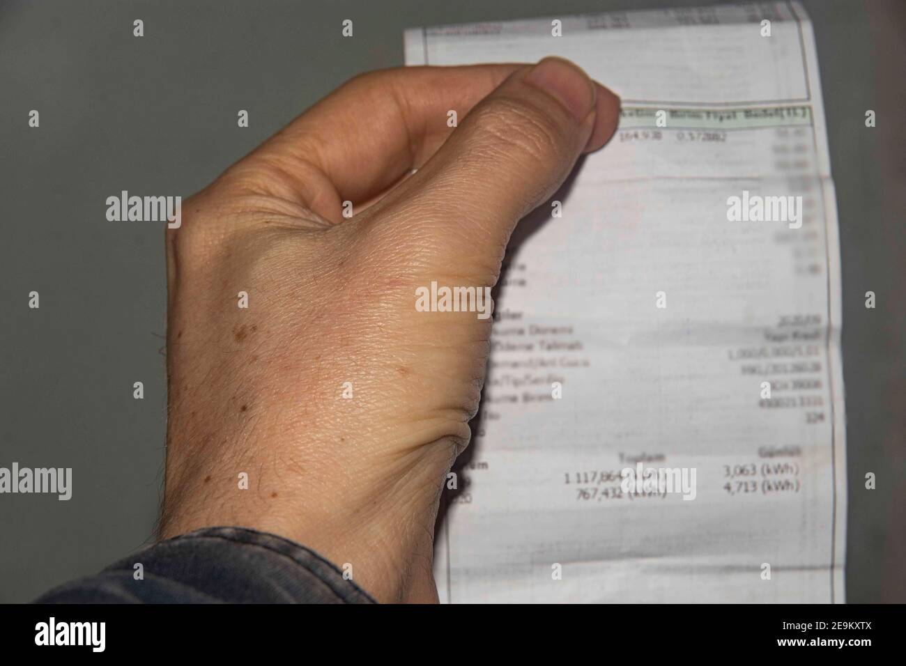 man holding bill in hand, bill blurred Stock Photo