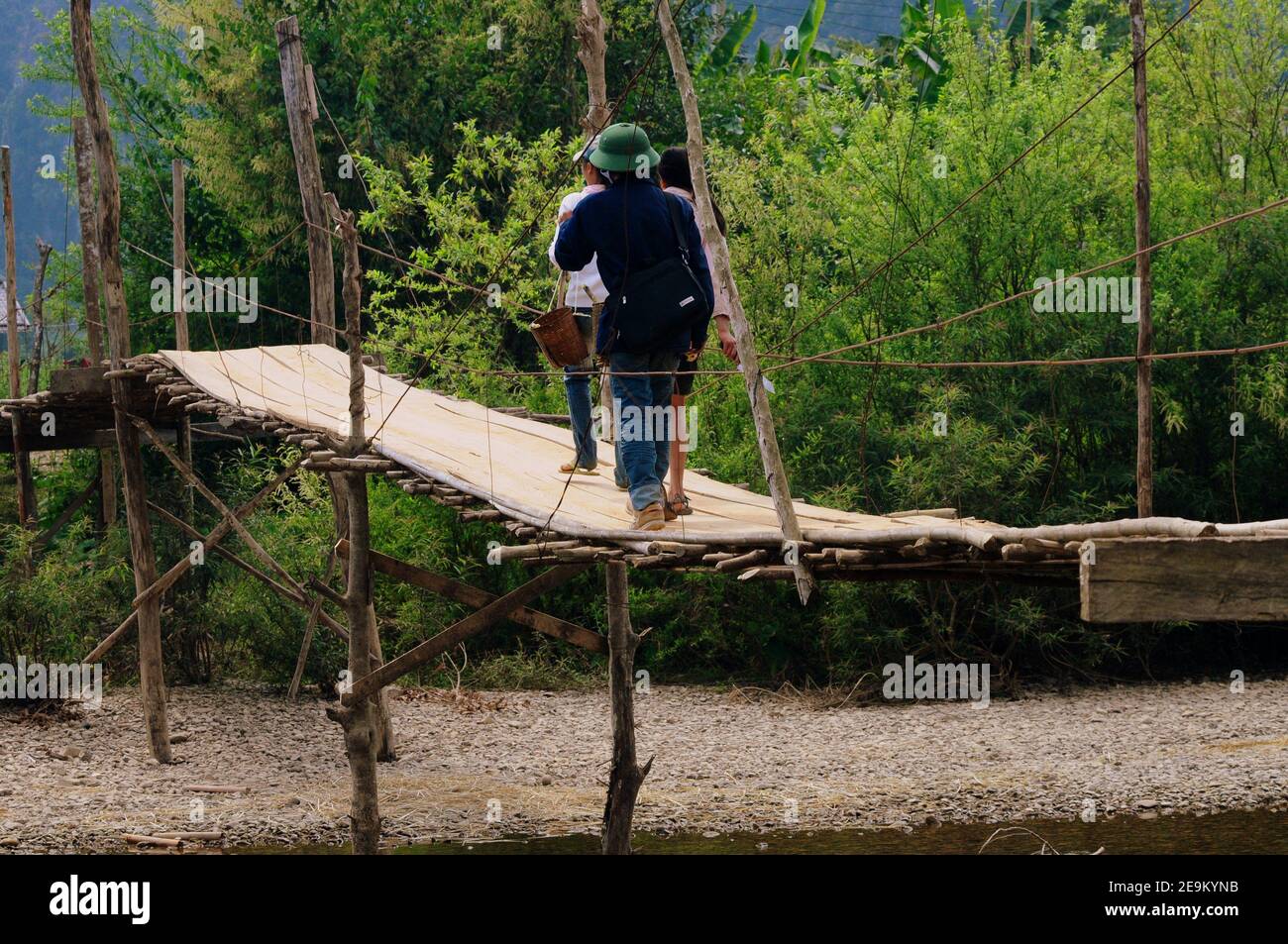 Tourists on a wooden bridge crossing the river Nam Song in Vang Vieng, Laos Stock Photo