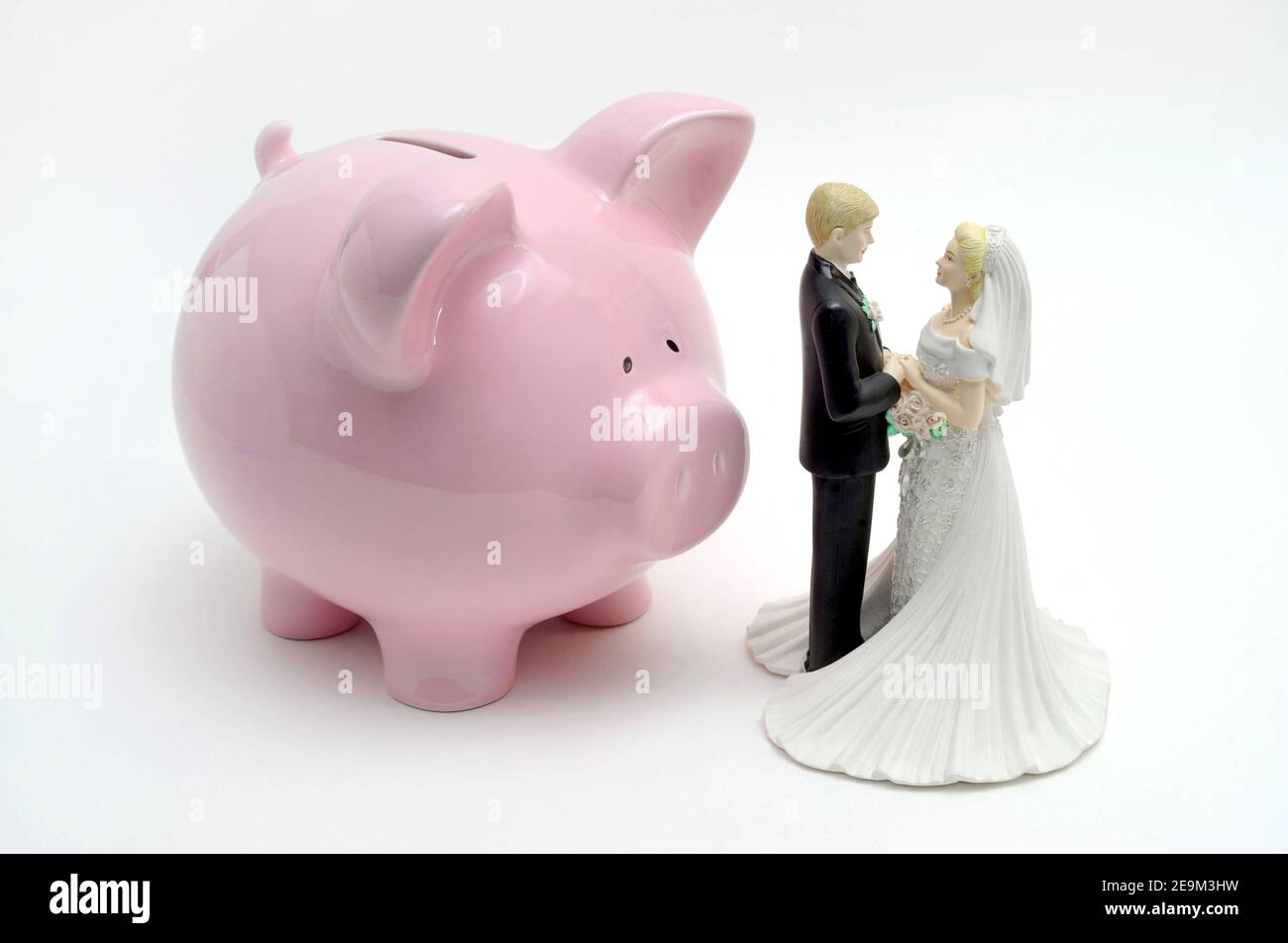 BRIDE AND GROOM FIGURES WITH PIGGY BANK RE WEDDING COSTS MARRIAGE SAVINGS ETC UK Stock Photo