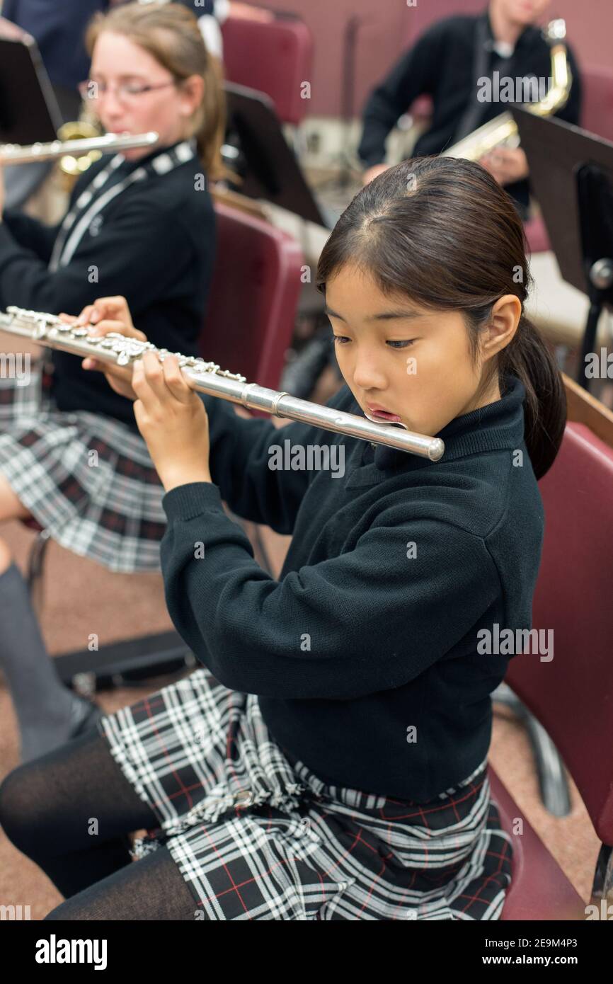 young female student practising flute in music class. Stock Photo
