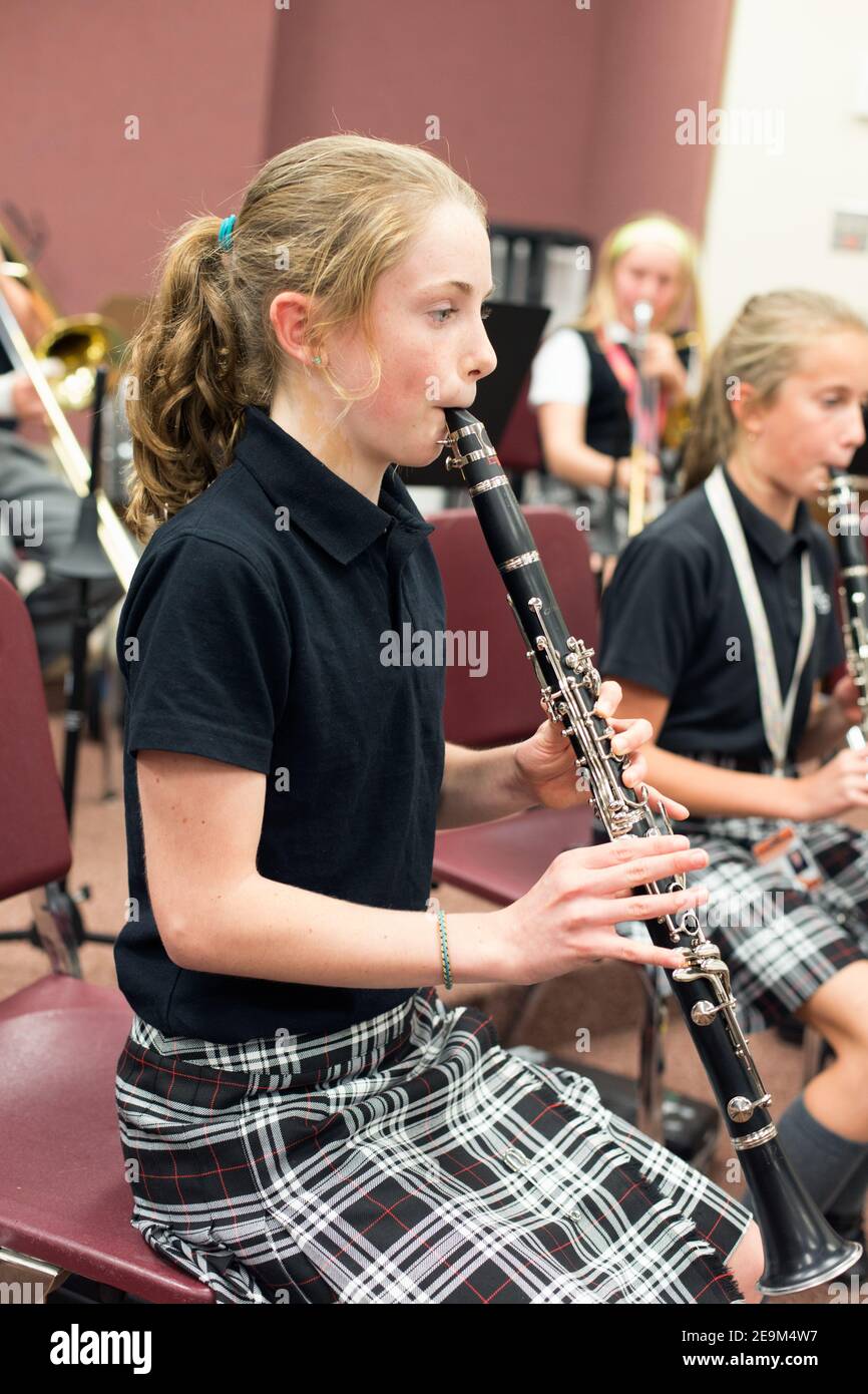 young female student practising clarinet  in music class. Stock Photo