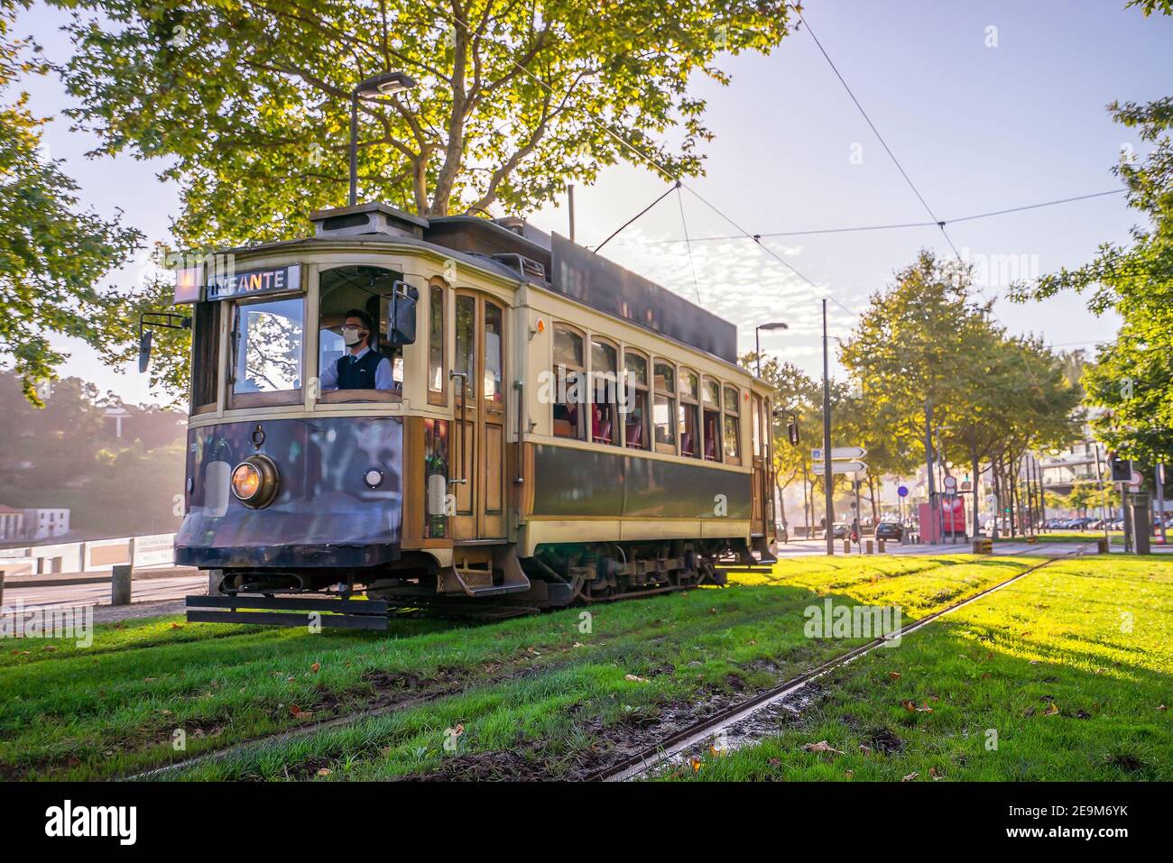 Porto, Portugal - August 12, 2020: Driver wearing mask conducting vintage tram heading city center of Porto by sunset, Portugal Stock Photo