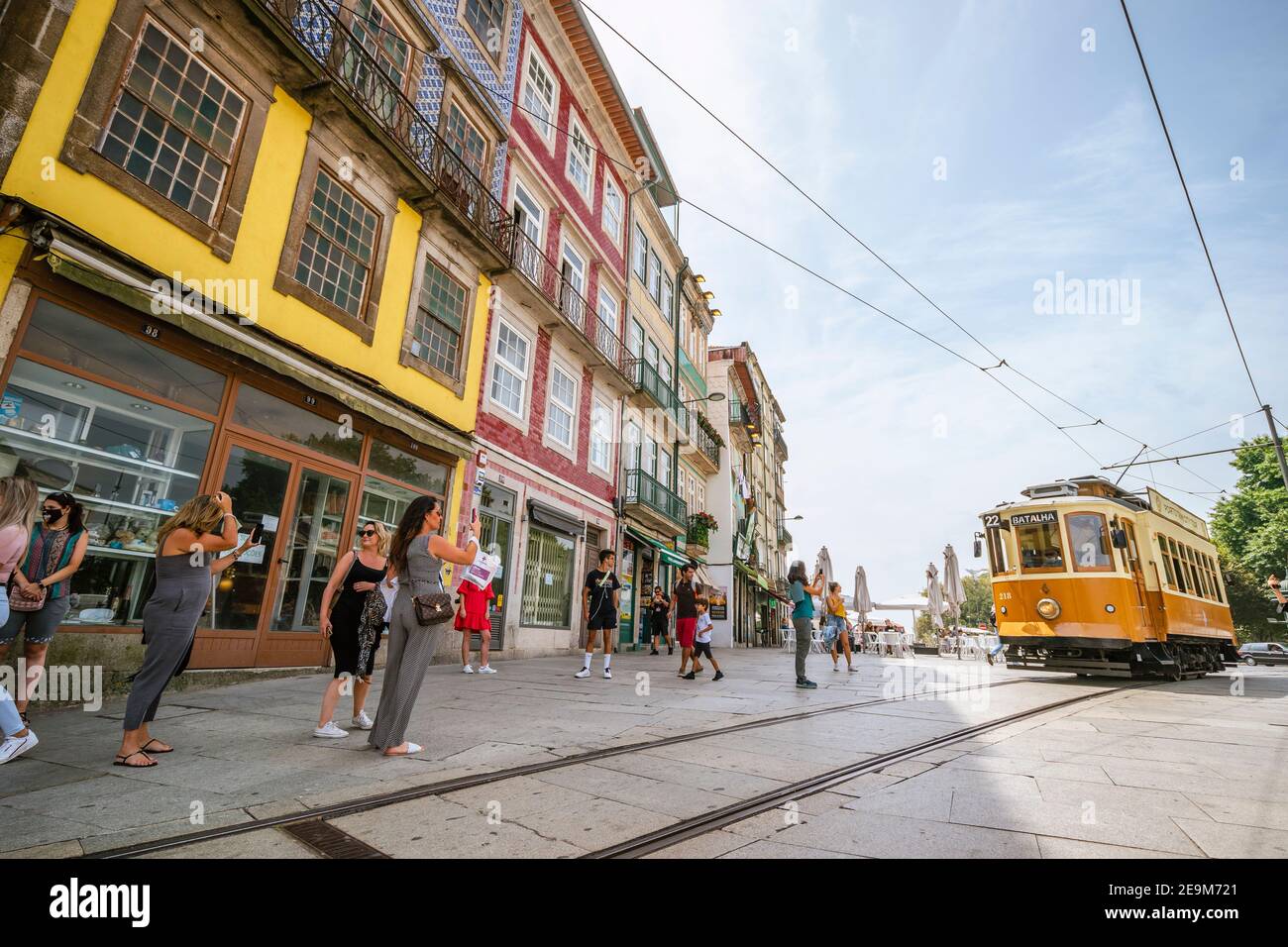 Porto, Portugal - August 11, 2020: Tourists taking photographs of approaching vintage tram Stock Photo