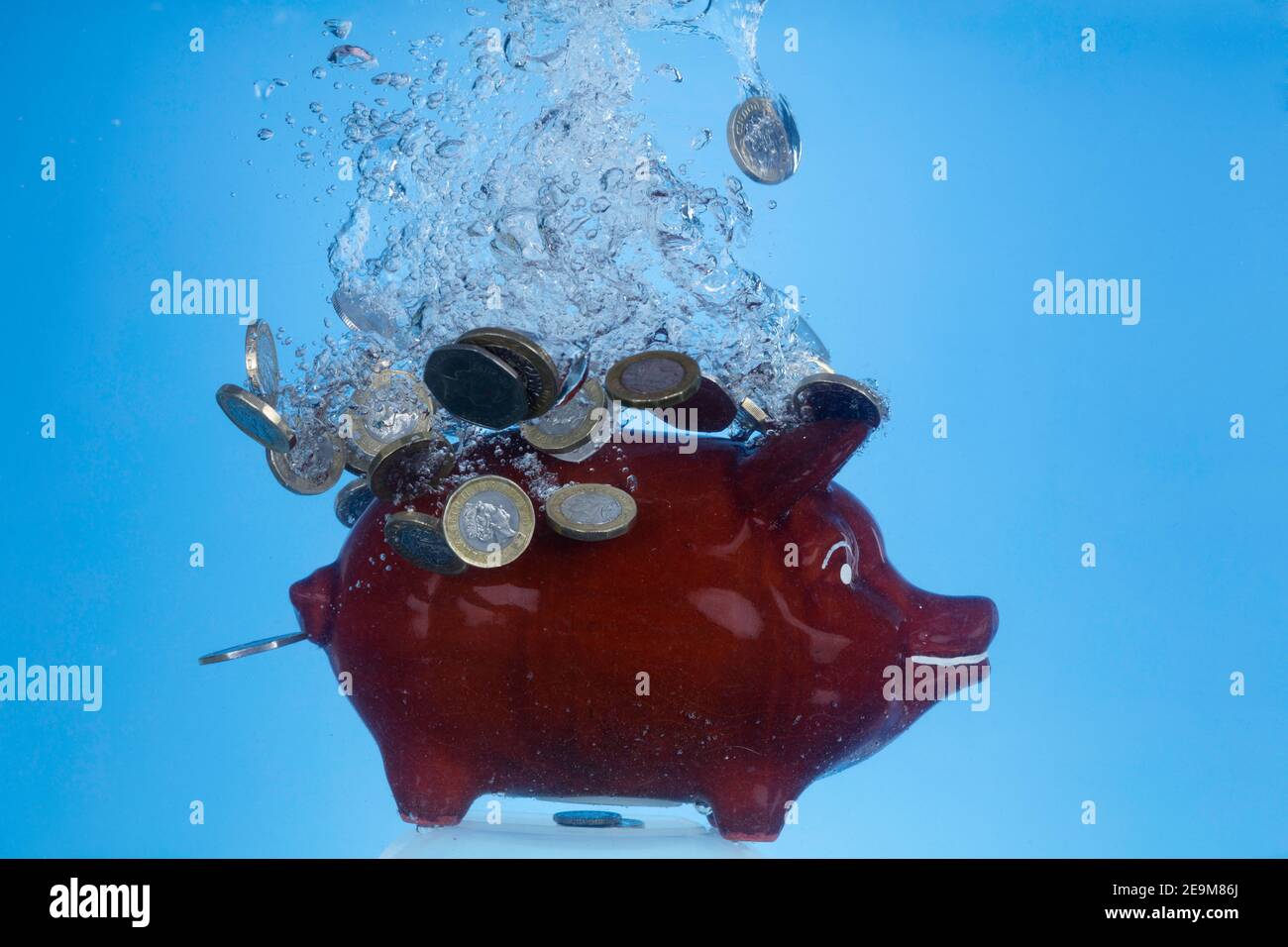 Freeze motion image of Piggy Bank and coins underwater (money