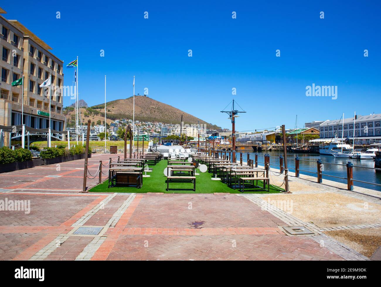 Waterfront- Cape Town, South Africa - 03-02-2021 Creative outdoor décor outside of Cape Town Fish Market. Communal tables and green rectangular area. Stock Photo