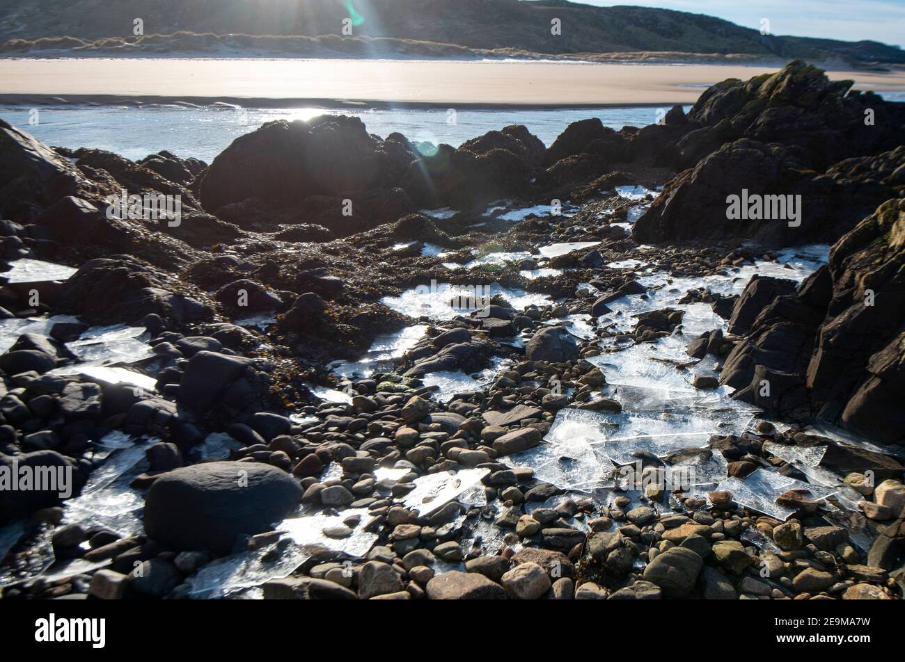 Frozen freshwater on the beach/rocks. Sheet ice Stock Photo