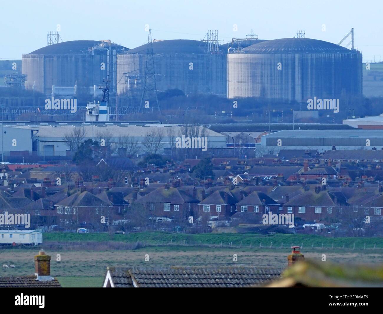 Minster on Sea, Kent, UK. 5th February 2021. Europe's largest Liquefied Natural Gas (LNG) terminal 'Grain LNG' on the Isle of Grain is set to expand with a 4th storage tank to be constructed over the next 4 years. French contractor VINCI won the contract for the €200 million euros project. The site is operated by the National Grid and can already meet 25% of the UK's gas demand. Pictured the huge existing 3 missile proof storage tanks as seen from Minster on Sea, Kent. Some have concerns over the terminal's proximity to shipwreck SS Richard Montgomery. Credit: James Bell/Alamy Live News Stock Photo