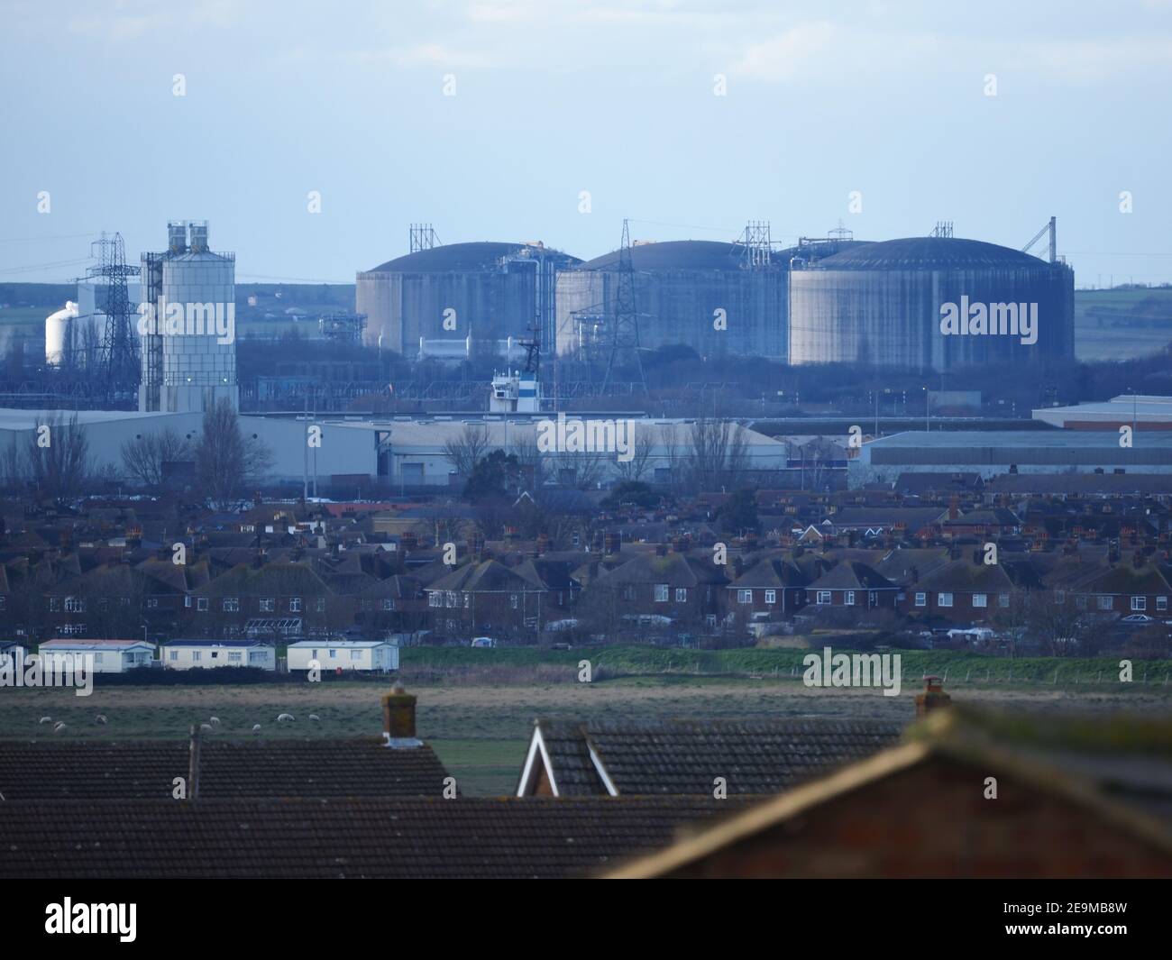 Minster on Sea, Kent, UK. 5th February 2021. Europe's largest Liquefied Natural Gas (LNG) terminal 'Grain LNG' on the Isle of Grain is set to expand with a 4th storage tank to be constructed over the next 4 years. French contractor VINCI won the contract for the €200 million euros project. The site is operated by the National Grid and can already meet 25% of the UK's gas demand. Pictured the huge existing 3 missile proof storage tanks as seen from Minster on Sea, Kent. Some have concerns over the terminal's proximity to shipwreck SS Richard Montgomery. Credit: James Bell/Alamy Live News Stock Photo