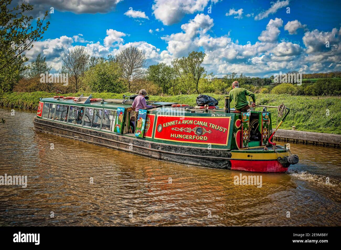 The colourful Kennet and Avon canal trust barge Rose of Hungerford makes its way down the Kennet and Avon Canal near Hungerford Berkshire on a bright Stock Photo
