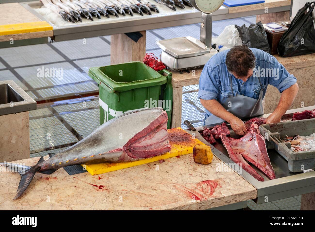 Fishmonger cutting up a tuna in Funchal market, Madeira, Portugal Stock Photo