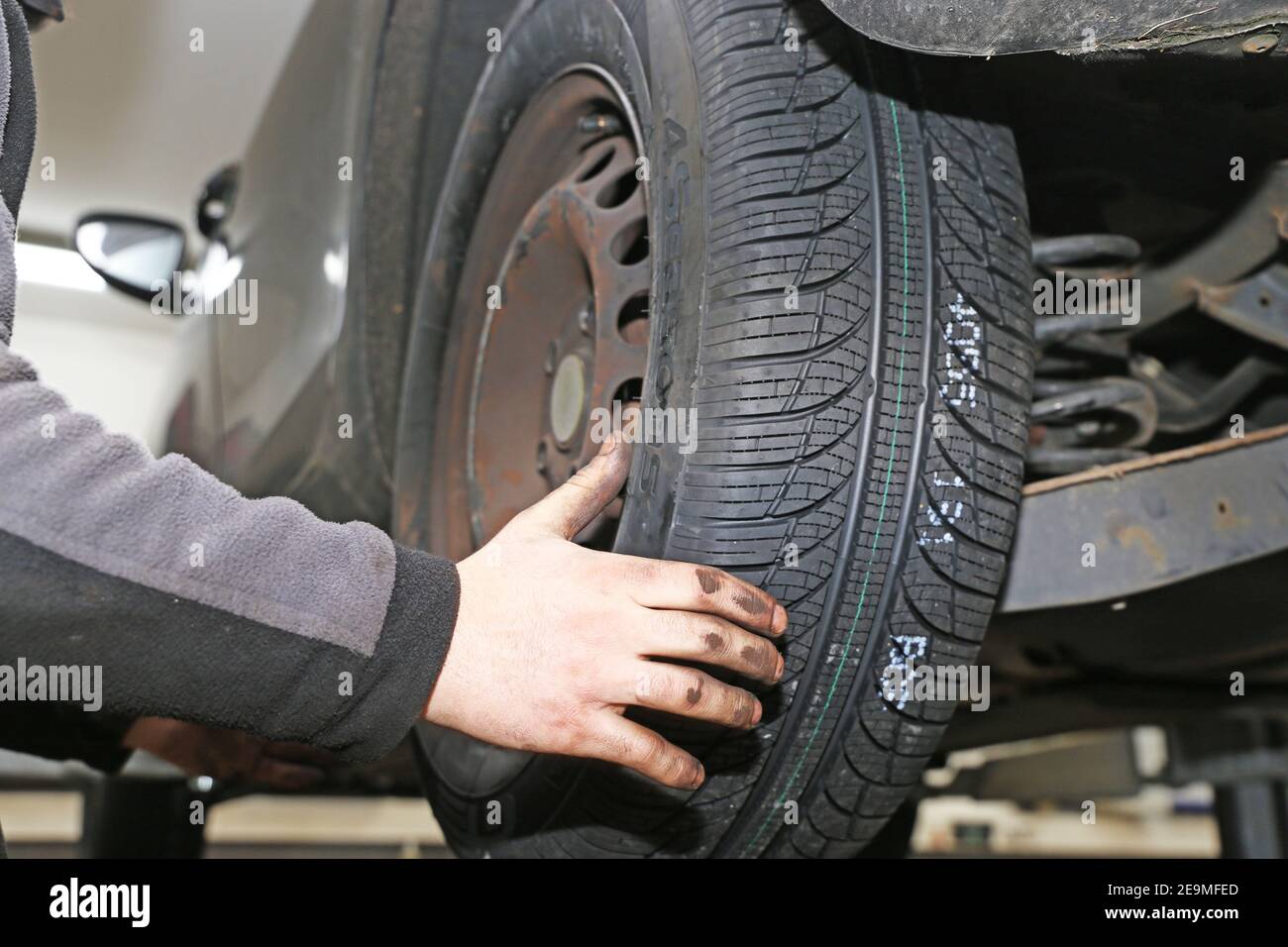 Mounting new all weather tires in the car (editorial Stock