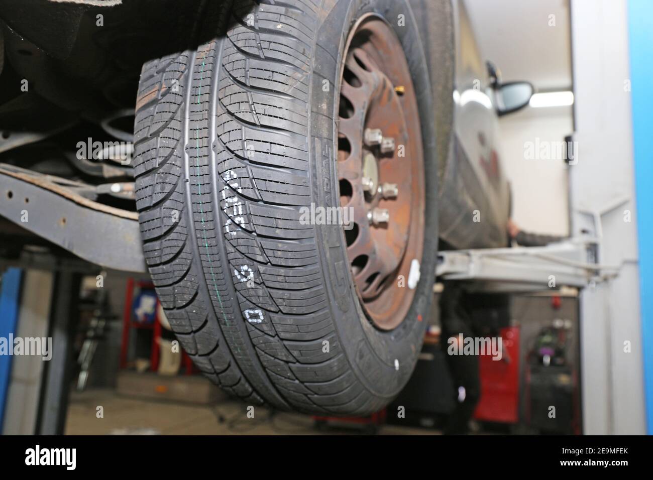 Mounting new all weather tires in the car (editorial Stock