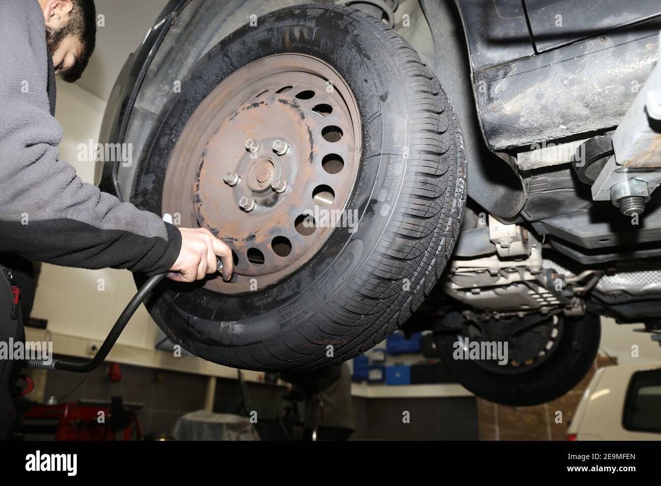 Mounting new all weather tires in the car (editorial Stock