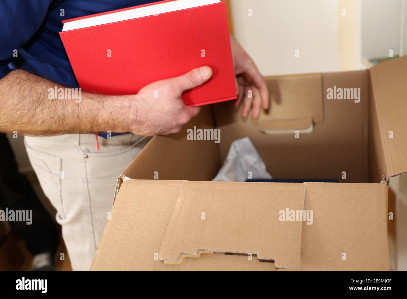 Moving company stows books in a moving box Stock Photo