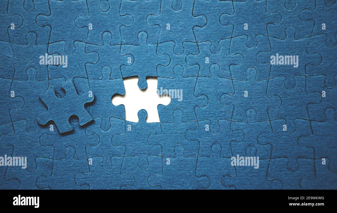 Top view flat lay of jigsaw puzzle with one piece missing .Concept of absence and incomplete.Putting the last piece finding solution Stock Photo