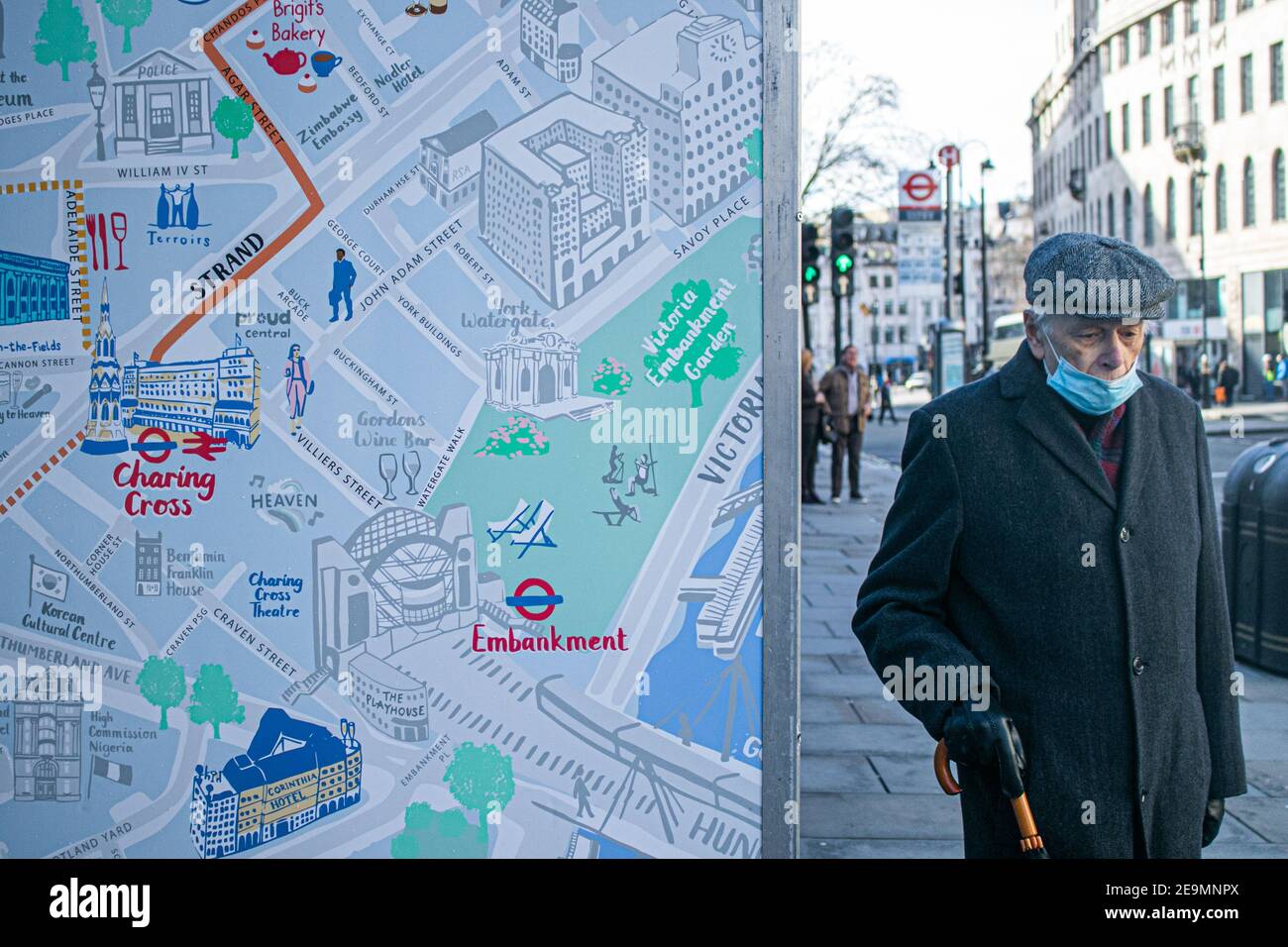 WESTMINSTER LONDON, UK 5 February 2021. A man  wearing a protective facemask walks past a map of  London's West End  as infection rates in the capital  continue to rise . Boroughs in West London has become a  Covid hotspot, although there was a sharp decline in cases in the east of the city which was hardest hit by the second wave. Credit: amer ghazzal/Alamy Live News Stock Photo