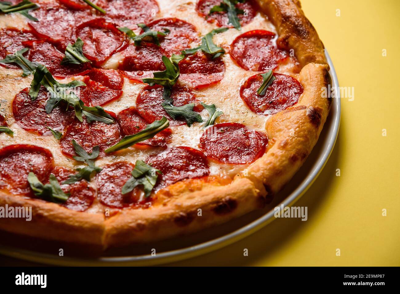 pizza on yellow background, pizza corner, salami, pepperoni, cheese on