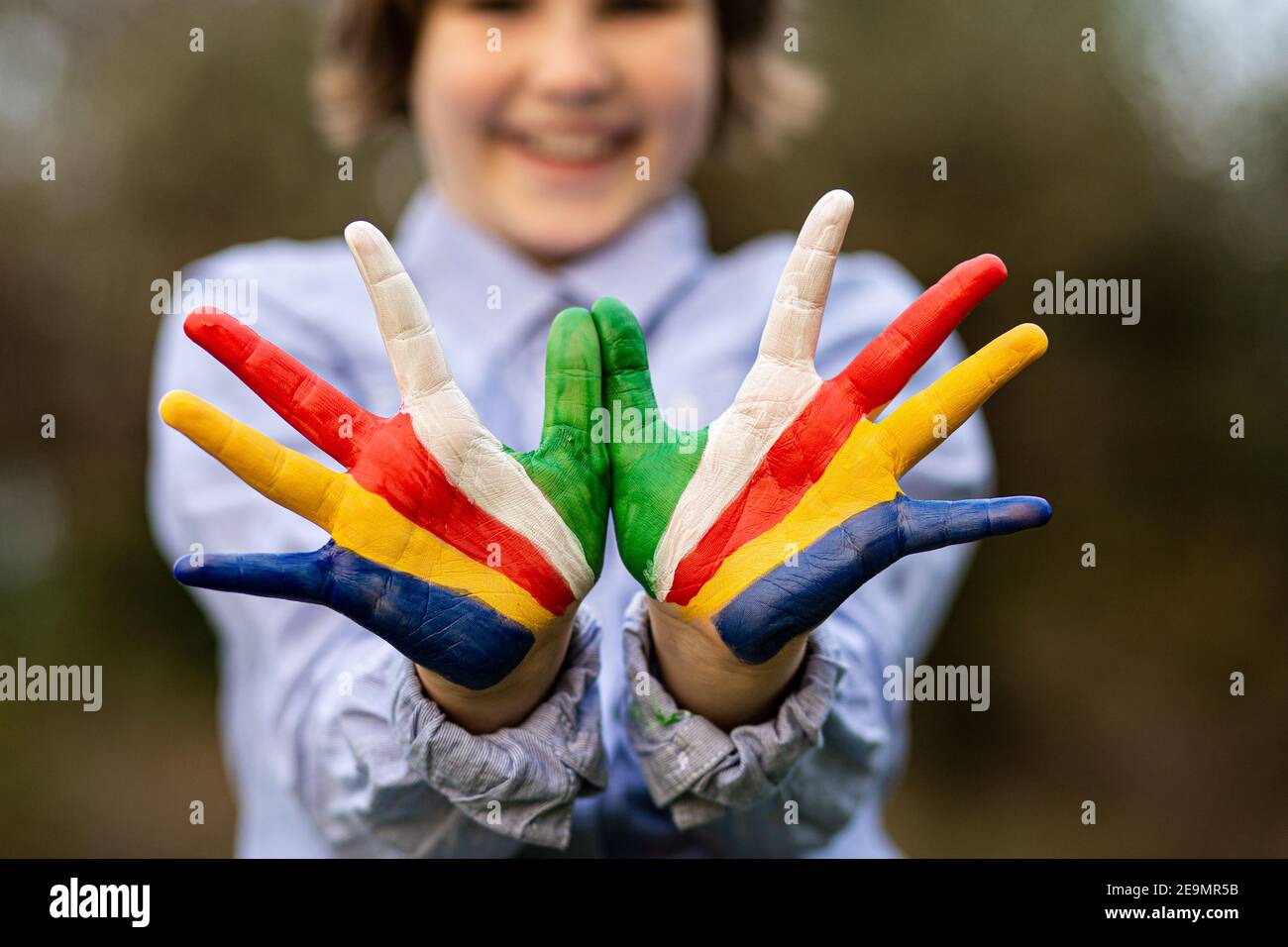 Freedom Seychelles concept. Cute child forming flying bird gesture with hands painted in Seychelles flag colors. Focus on hands Stock Photo