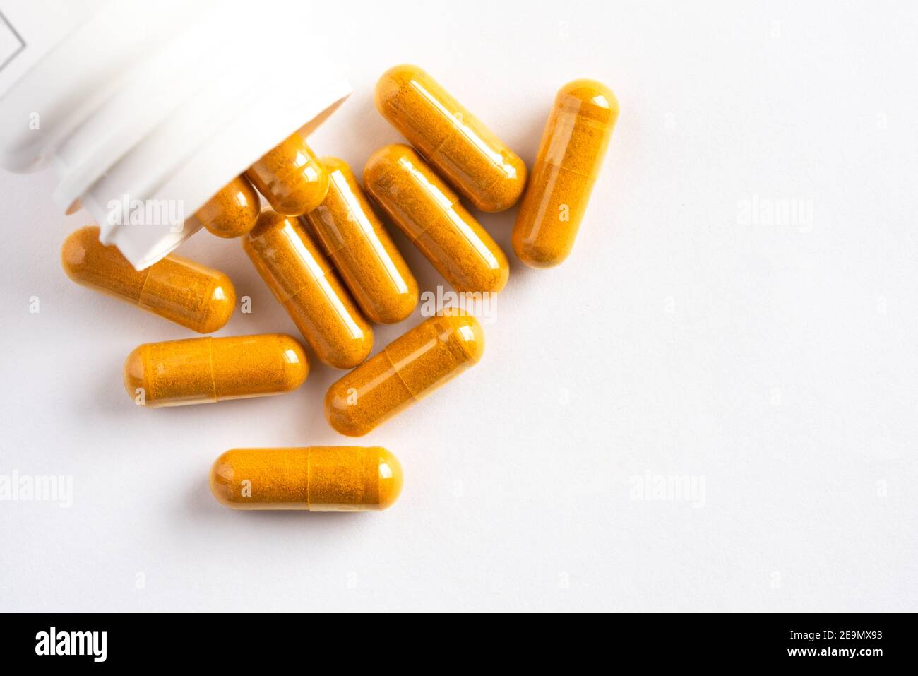Turmeric Root Capsules Spilled from a Bottle Stock Photo