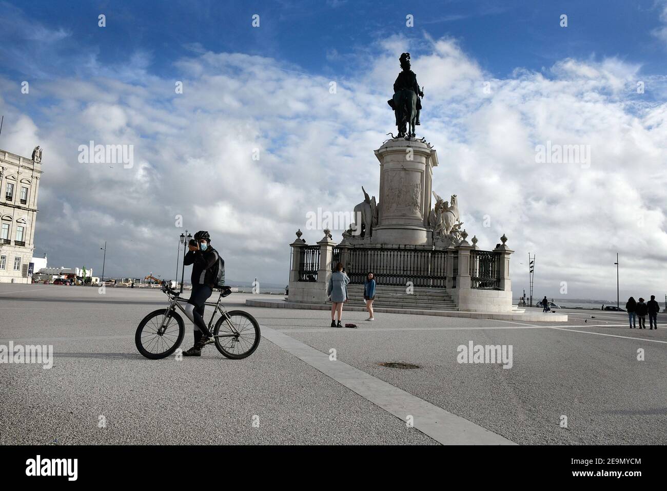A man wearing a face mask takes pictures from his bicycle in Praça de Comercio. Portugal has registered 13,740 deaths and 755,774 confirmed cases since the beginning of the pandemic according to the bulletin of the General Health Department (DGS). Stock Photo