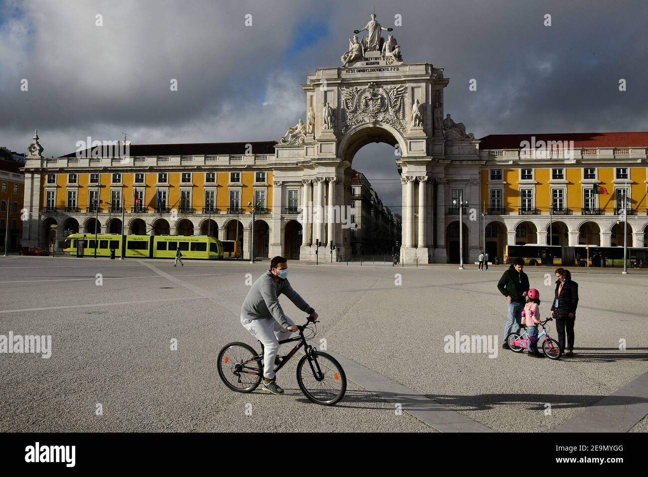 A man wearing a face mask rides his bicycle in Praça de Comercio. Portugal has registered 13,740 deaths and 755,774 confirmed cases since the beginning of the pandemic according to the bulletin of the General Health Department (DGS). Stock Photo