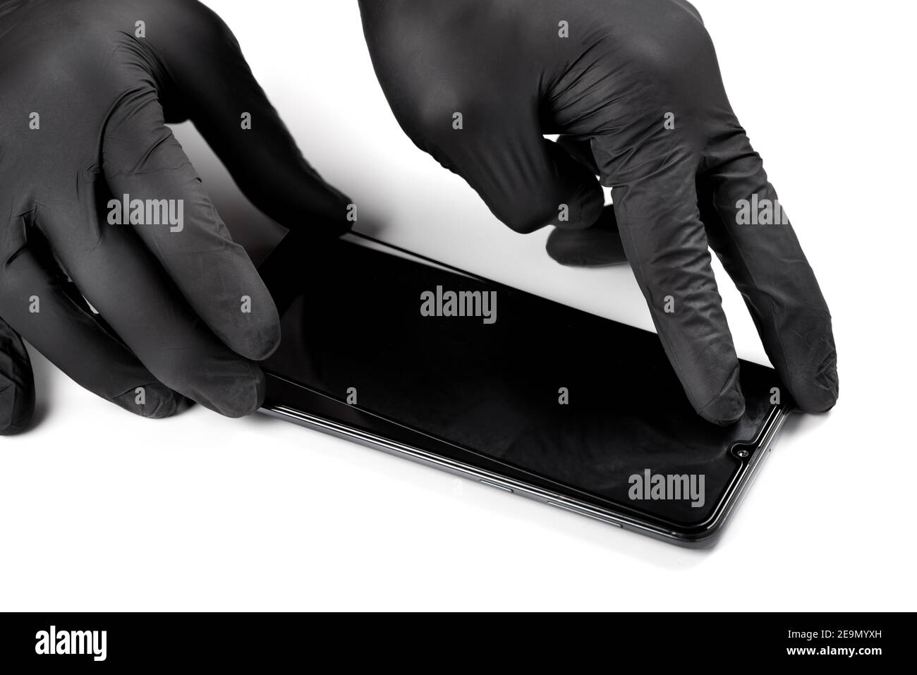 A man is installing a protective glass on the screen of a smartphone. Stock Photo