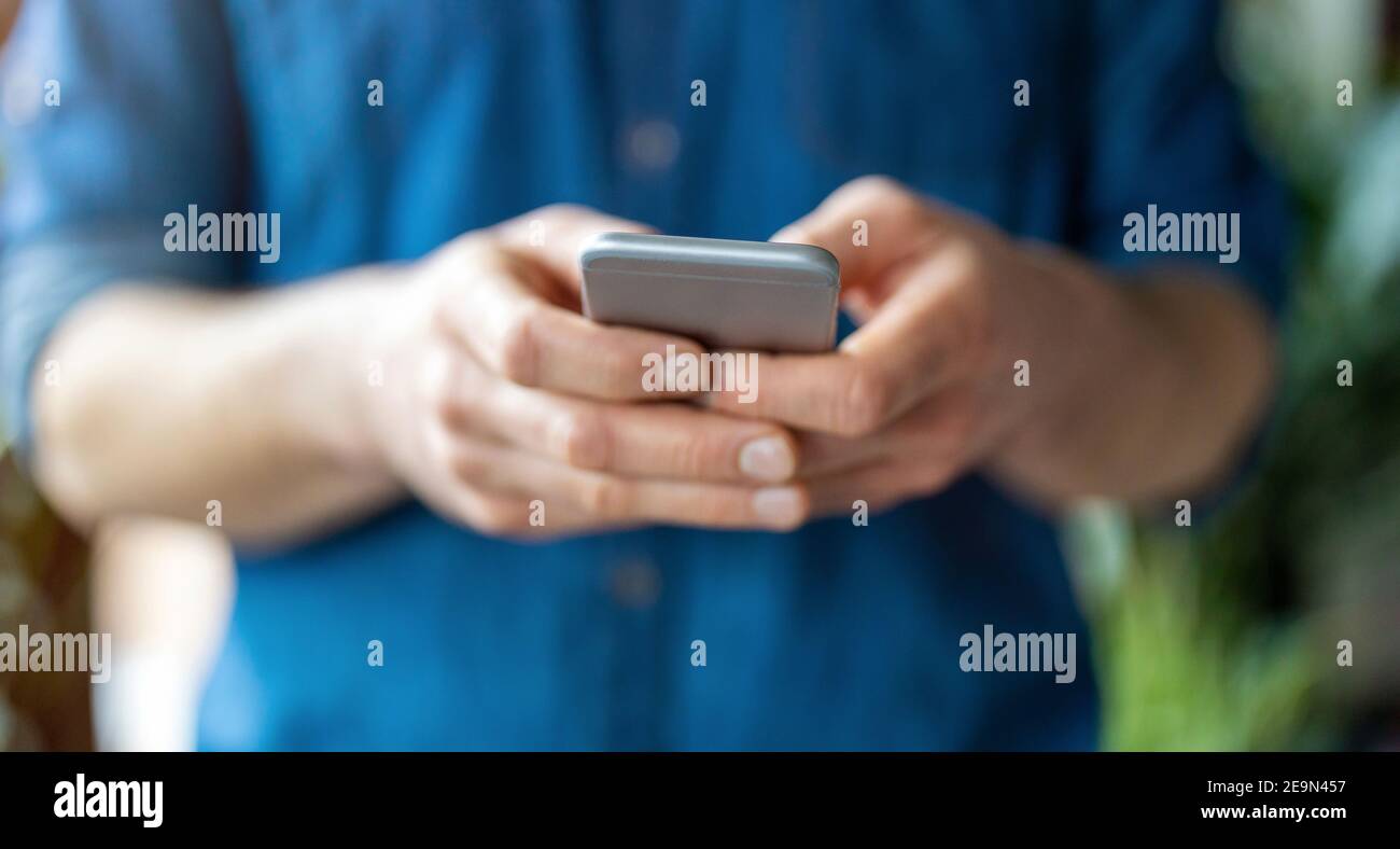 Male hands typing on smartphone Stock Photo