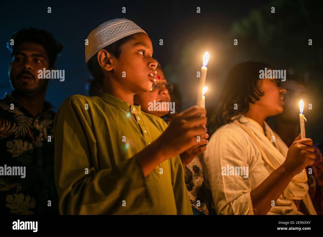 A young boy holding a burning candle during the vigil. Bangladeshi