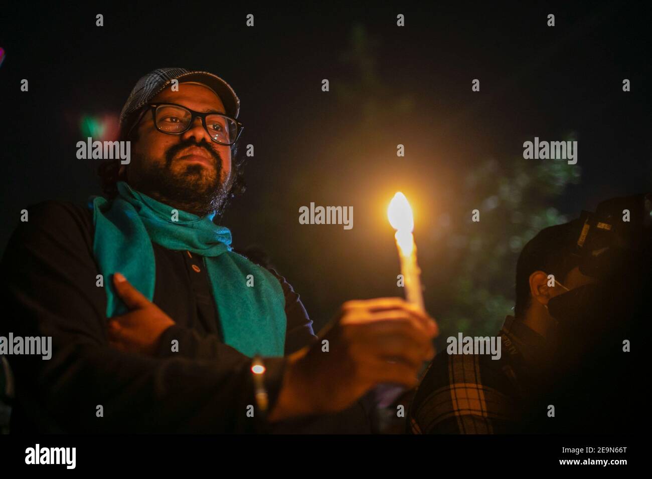 An activist holding a burning candle during the vigil. Bangladeshi