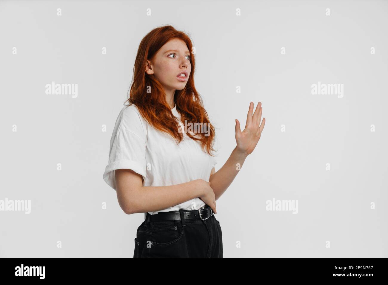 Ginger beautiful scared girl looking aside and making stop gesture ...