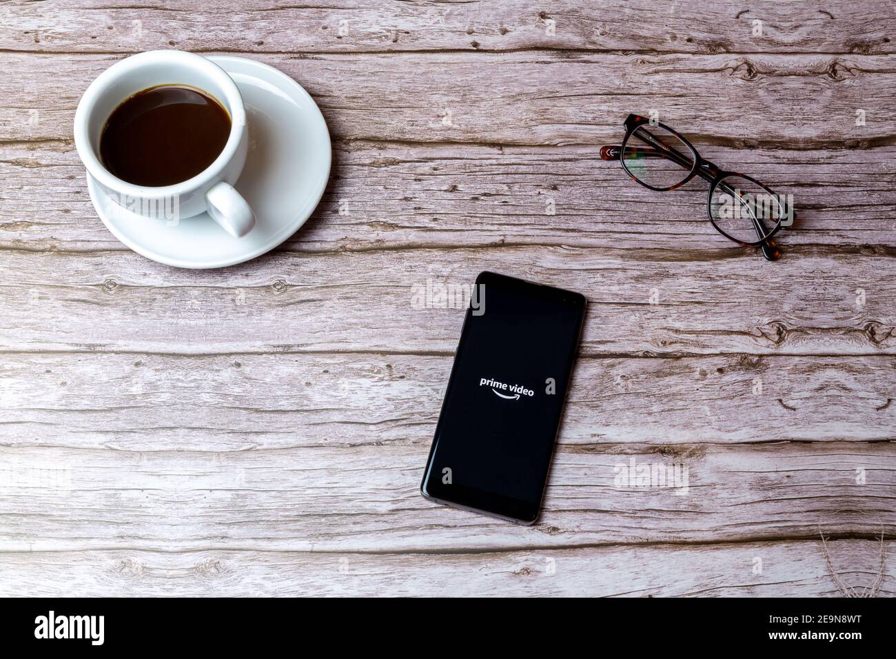 A mobile phone or cell phone laid on a wooden table or desk with the