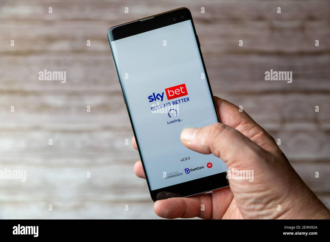 A Mobile phone or cell phone being held showing the Sky bet app open on screen Stock Photo