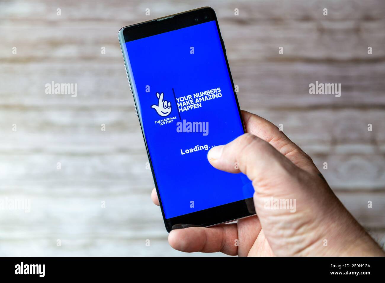A Mobile phone or cell phone being held showing the National lottery or Lotto app open on screen Stock Photo