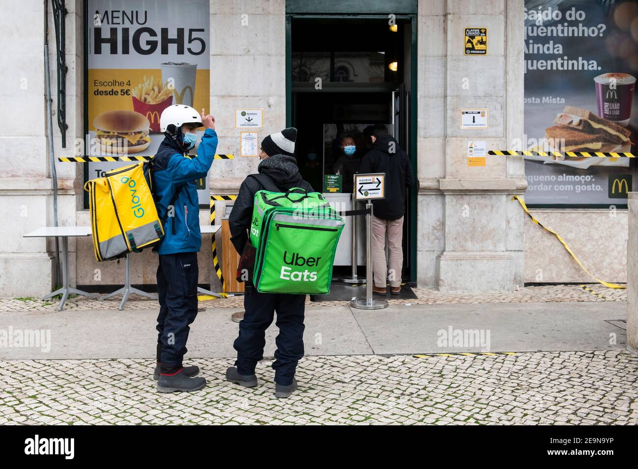 Uber Eats and Glovo couriers seen waiting to pick up orders at a 