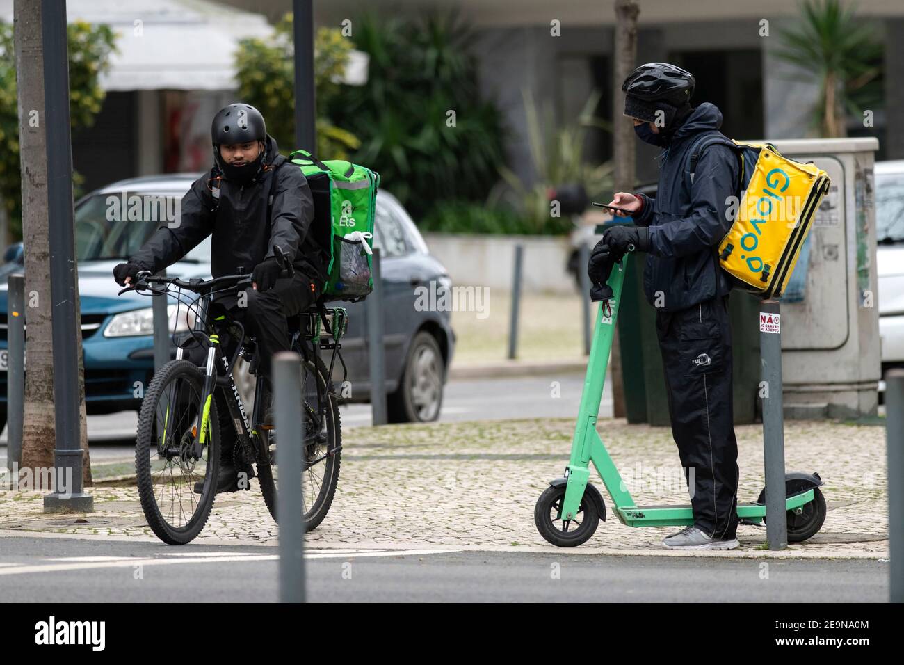 Uber Eats and Glovo couriers seen waiting for online orders in 