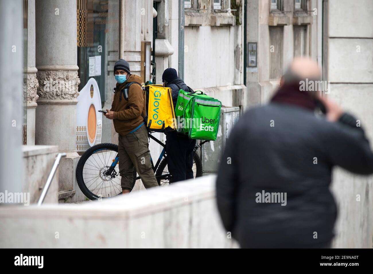 Uber Eats and Glovo couriers seen waiting to pick up orders at a 