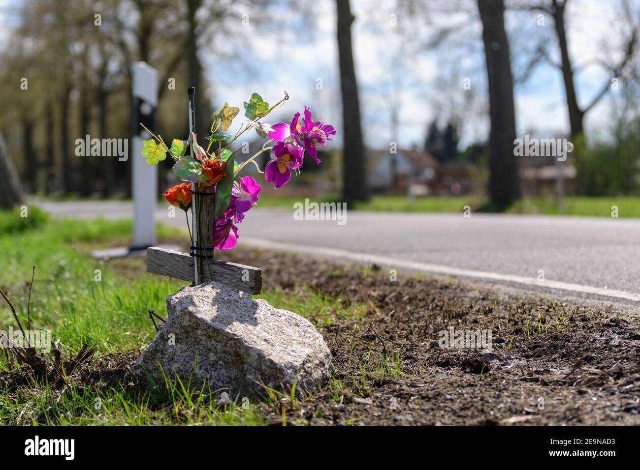 Memorial cross with flowers at the scene of an accident at the roadside Stock Photo