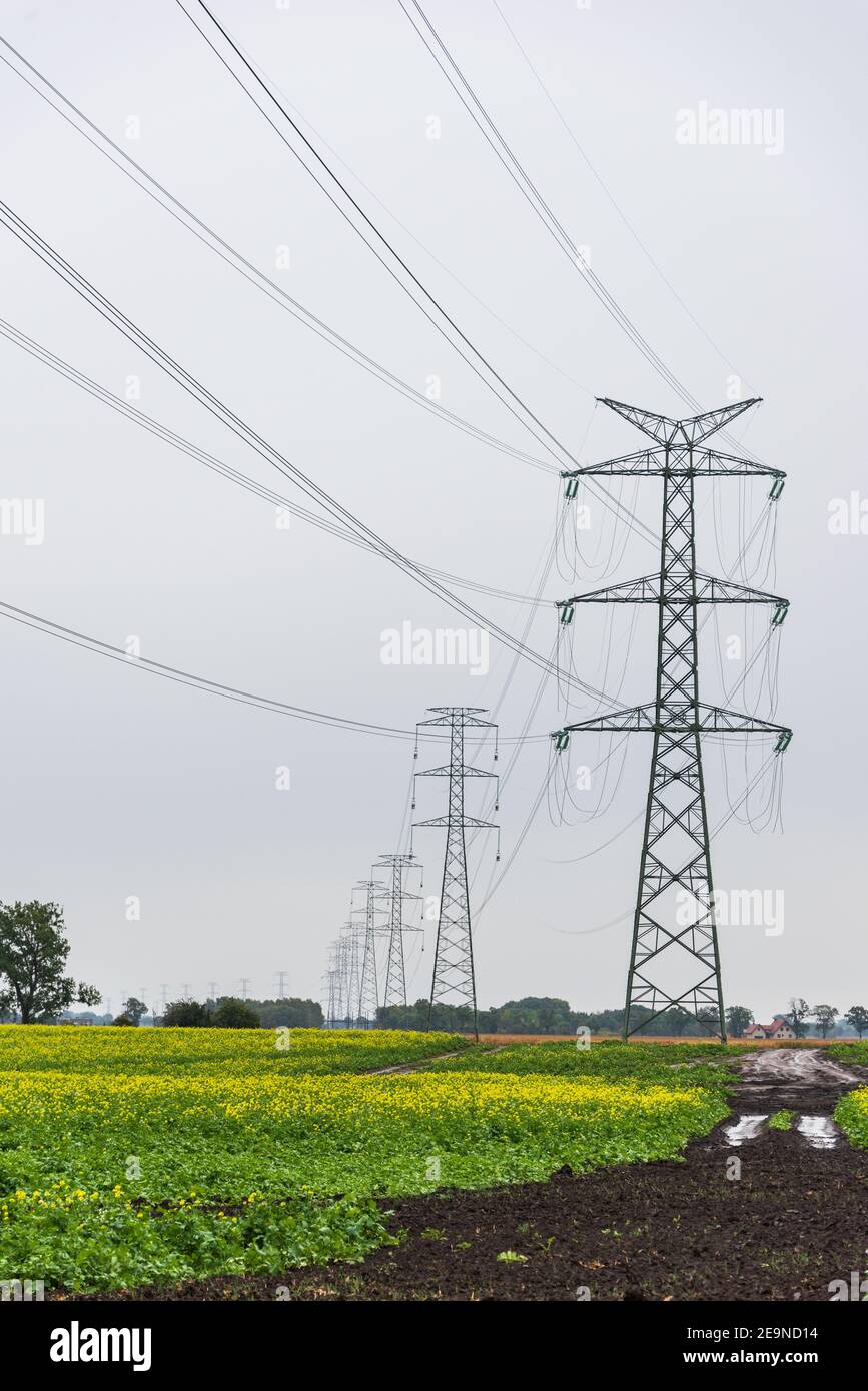 Extra-high voltage 400 kV overhead power line on large pylons, used for long distance, very high power transmission. Cloudy sky and copy space Stock Photo