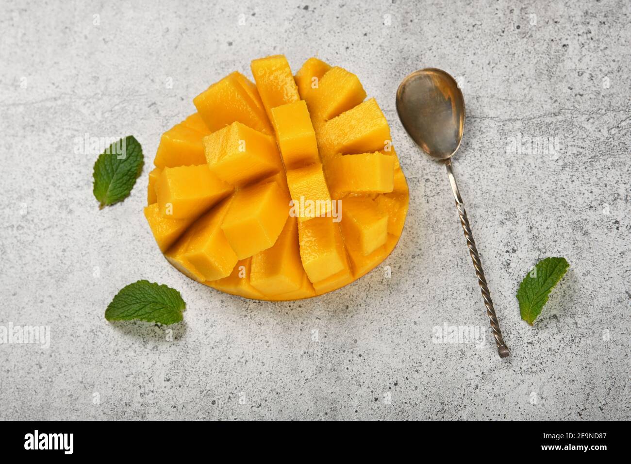 Close up serving fresh ripe cut mango dessert on gray stone table, elevated top view, directly above Stock Photo