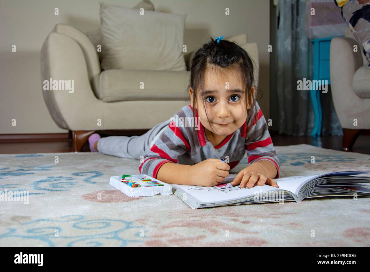 Little girl looking at the camera while painting on the floor Stock ...