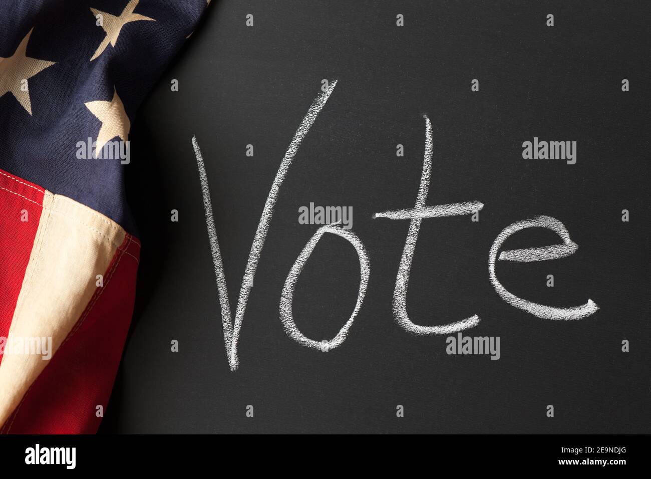 A vote sign written on a chalkboard with vintage American flag Stock Photo