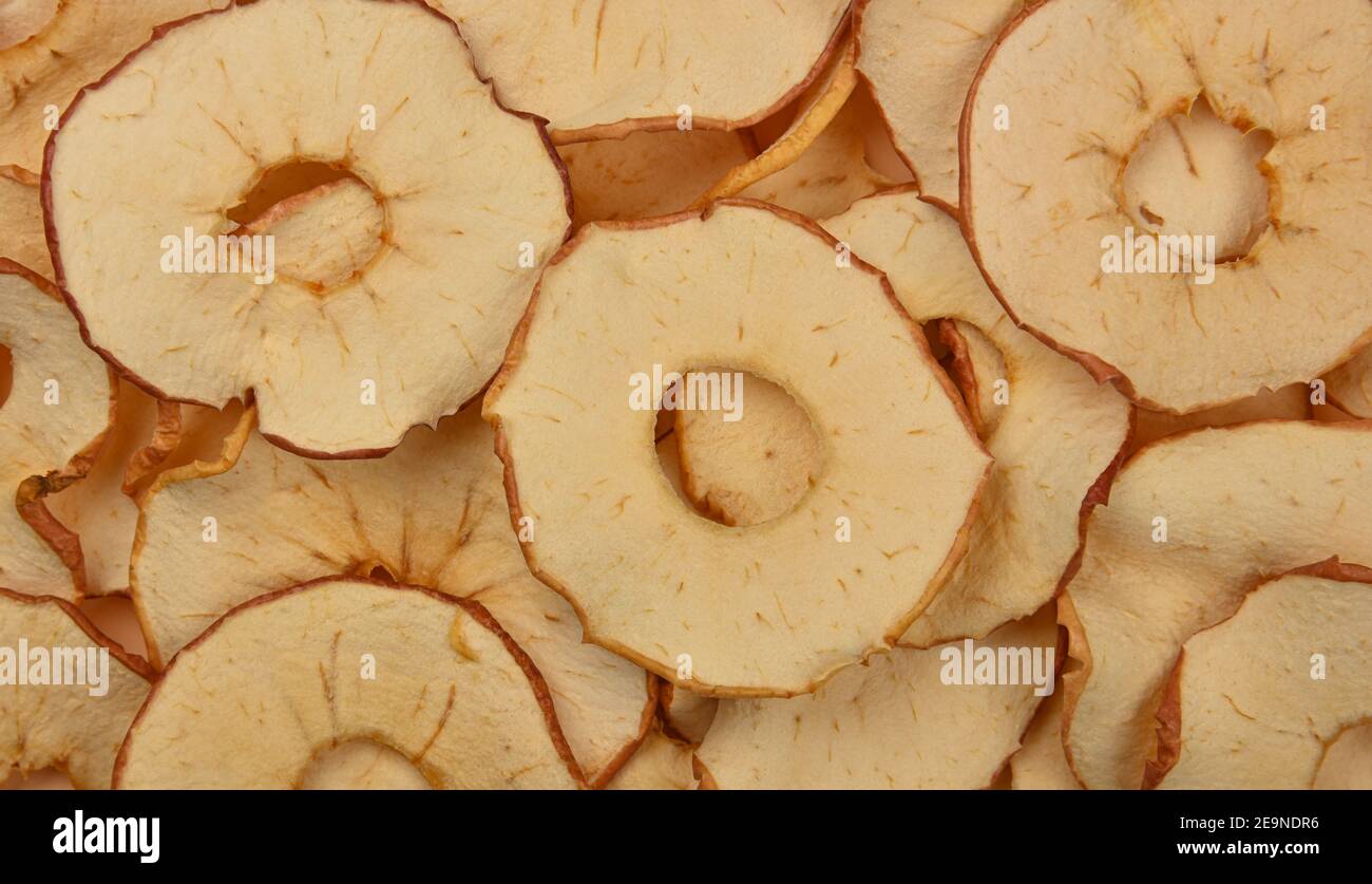 Close up many dried crispy apple ring chips on retail display, elevated top view, directly above