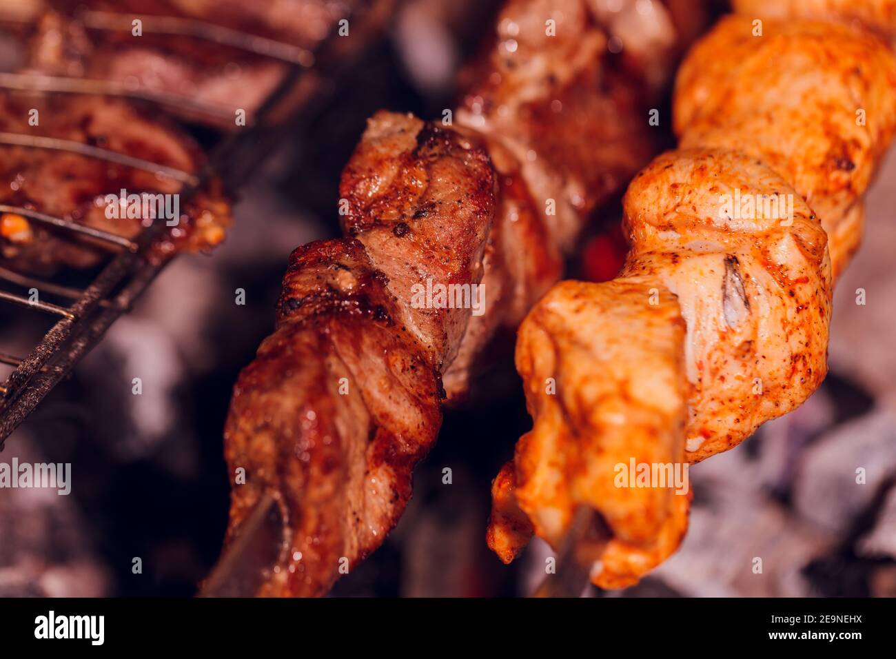 Grilled kebab cooking on metal skewer. Roasted meat cooked at barbecue. BBQ fresh beef meat chop