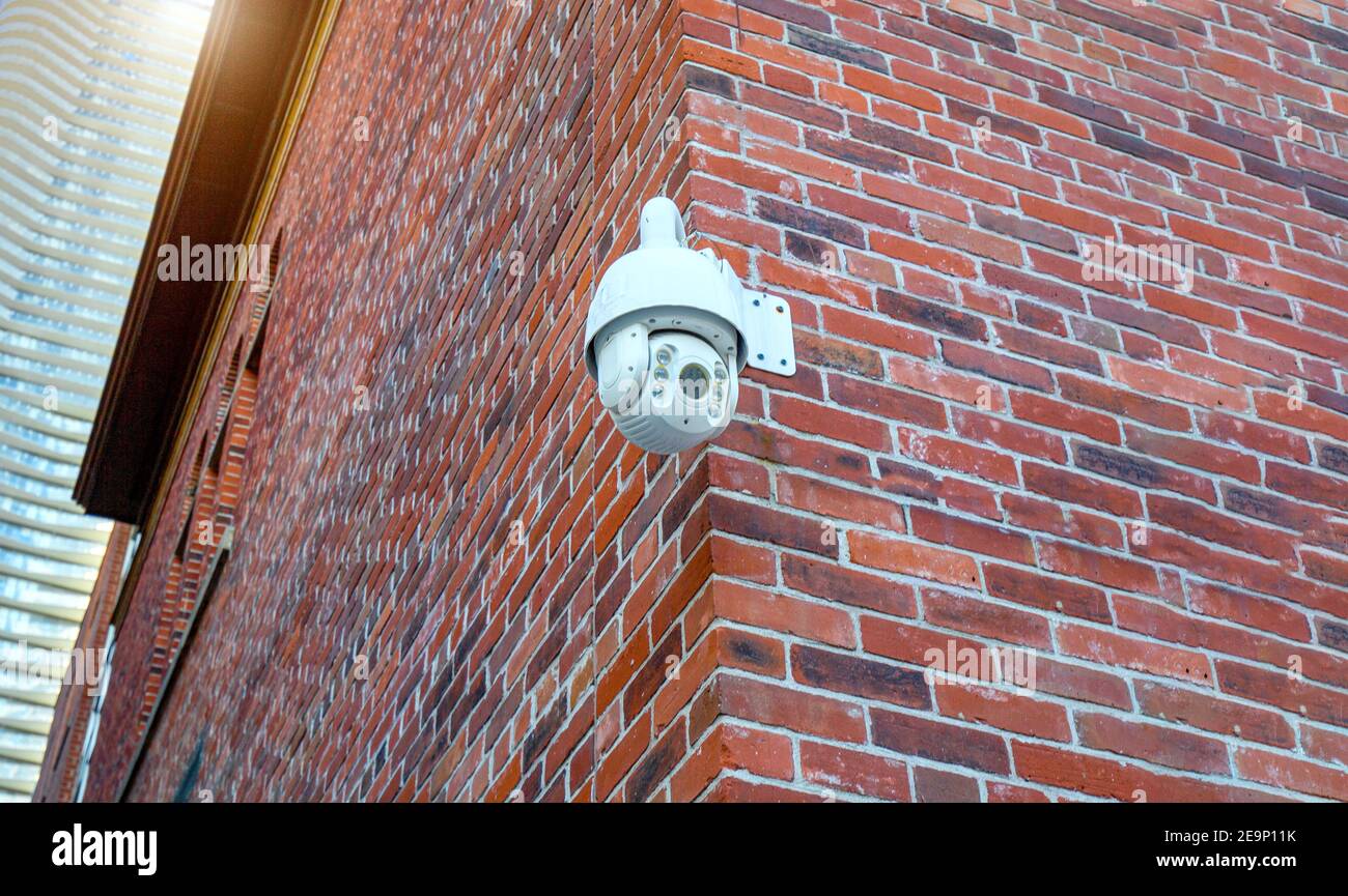 Security CCTV camera mounted on the corner of the building monitoring
