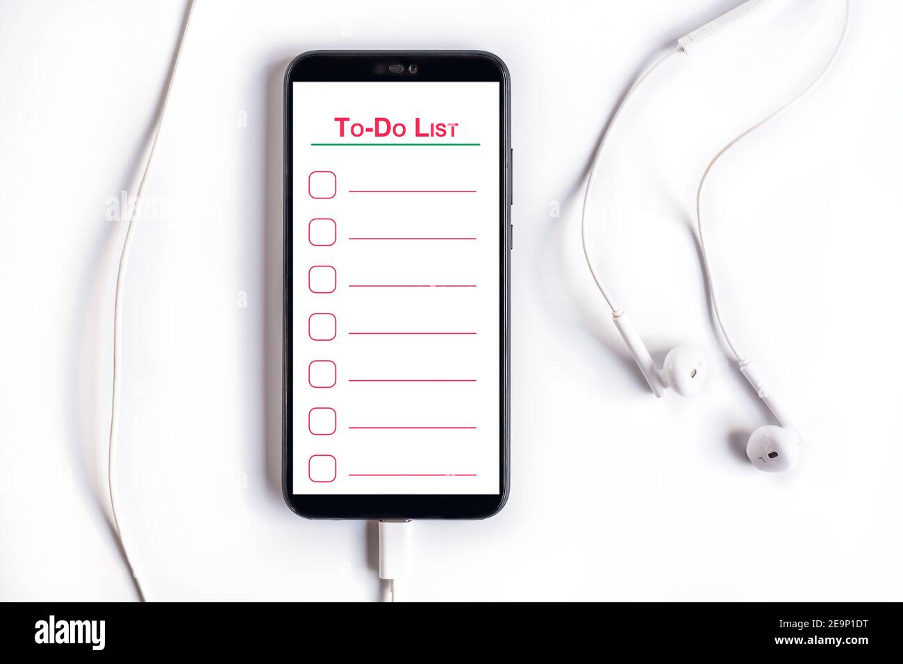 Smartphone with empty to-do list with earphones on a wooden table Stock Photo