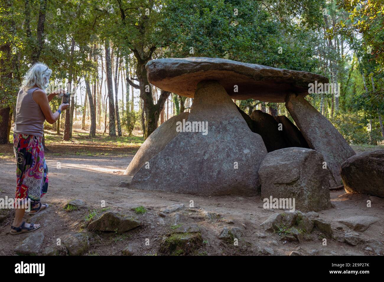 Europe, Spain, Galicia, Ribeira, Tourist photographing Dolmen de Axeitos (prehistoric megalithic burial chamber) Stock Photo