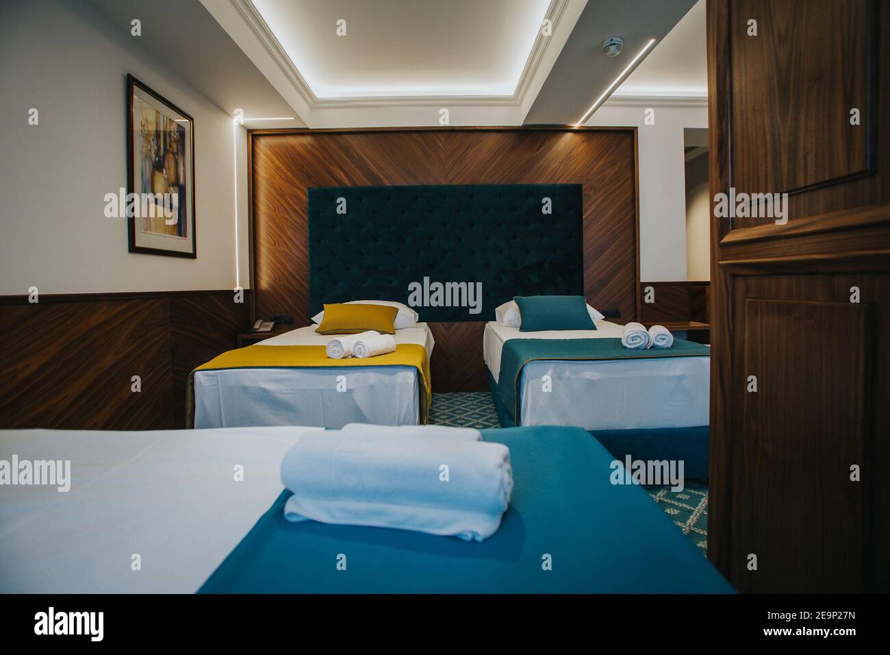 Interior of a bedroom with three beds and soft pillows in the hotel