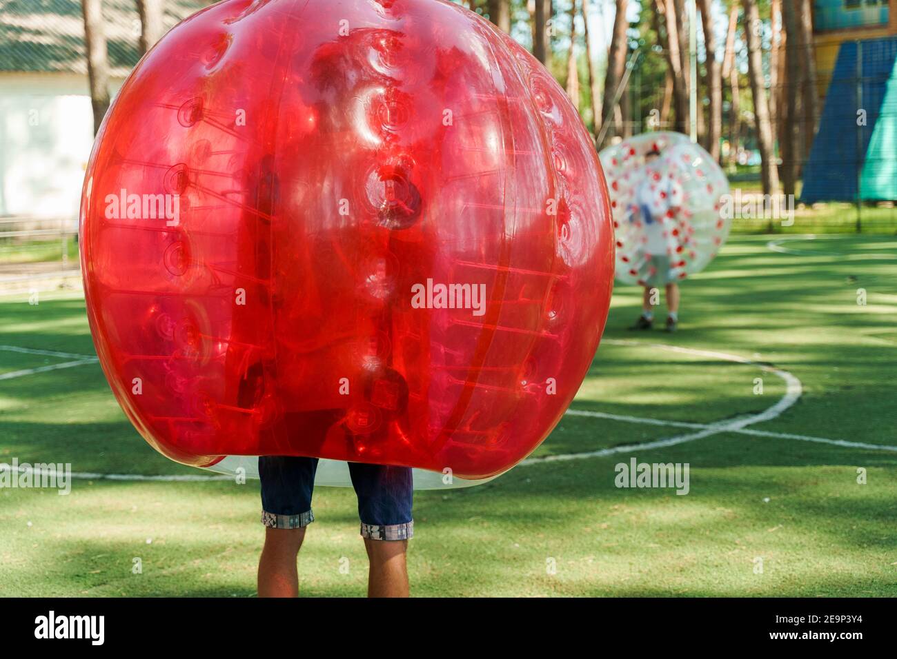Bubble football sport game. Football players play bumperball on the