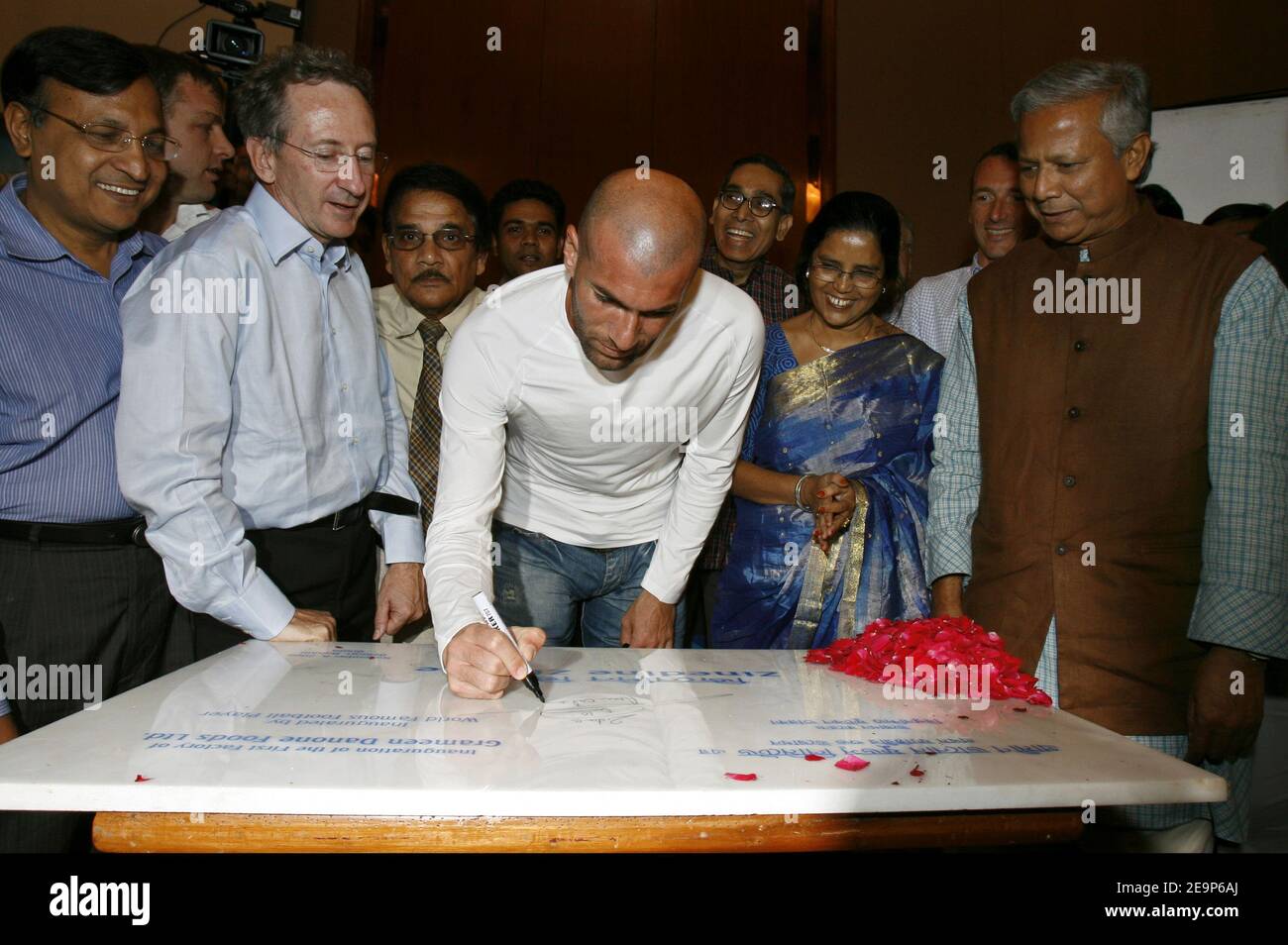 French football player Zinedine Zidane signs his autograph with Danone CEO Franck Riboud and Bangladeshi Nobel Peace Prize winner Muhammad Yunus on a stone as he officially opens a yogurt factory project run by French food giant Danone and Grameen Bank at a ceremony in Dhaka, Bangladesh on November 8, 2006. The project set up in the northern Bangladesh town of Bogra will produce nutritious food products for the people in the low income area. Photo by Patrick Durand/Cameleon/ABACAPRESS.COM Stock Photo